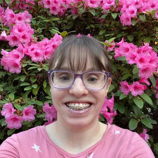 Picture of me with beautiful pink rhododendron behind me